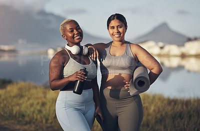 Buy stock photo Shot of two young women holding a water bottle and yoga mat while standing outside