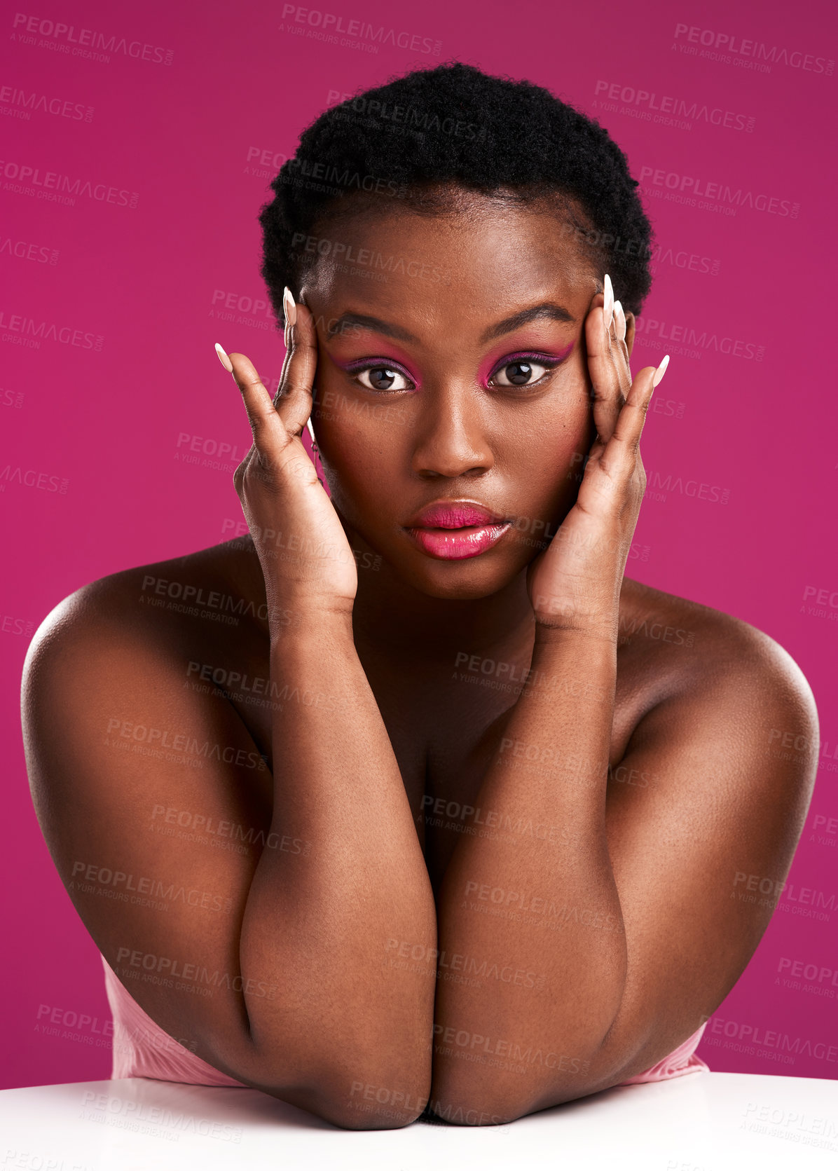 Buy stock photo Studio shot of a beautiful young woman resting on a table against a pink background