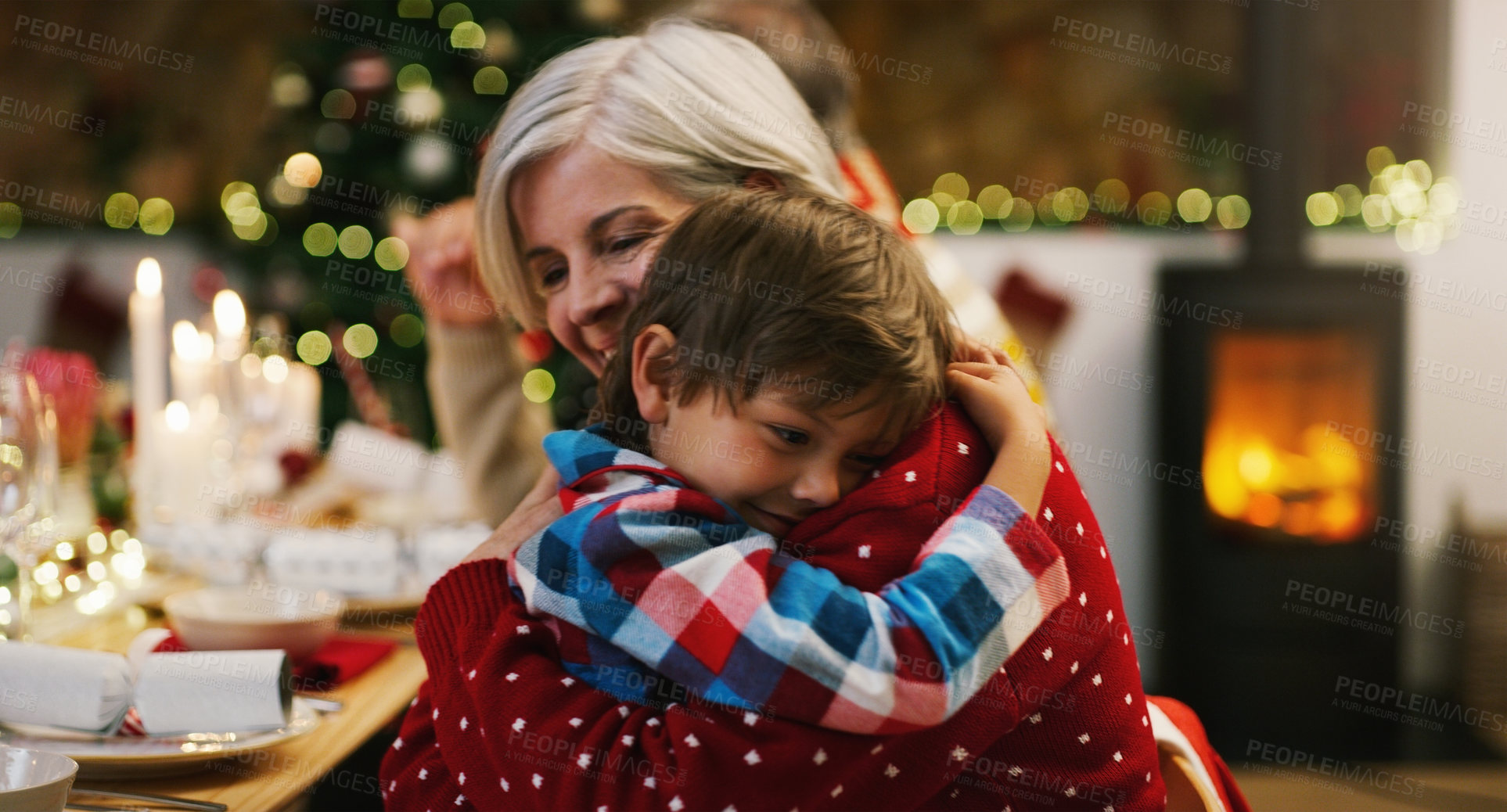 Buy stock photo Christmas, love and a grandma hugging her grandchild in the home during the festive season together. Family, children or holiday with a young boy and senior woman in a house to hug while bonding