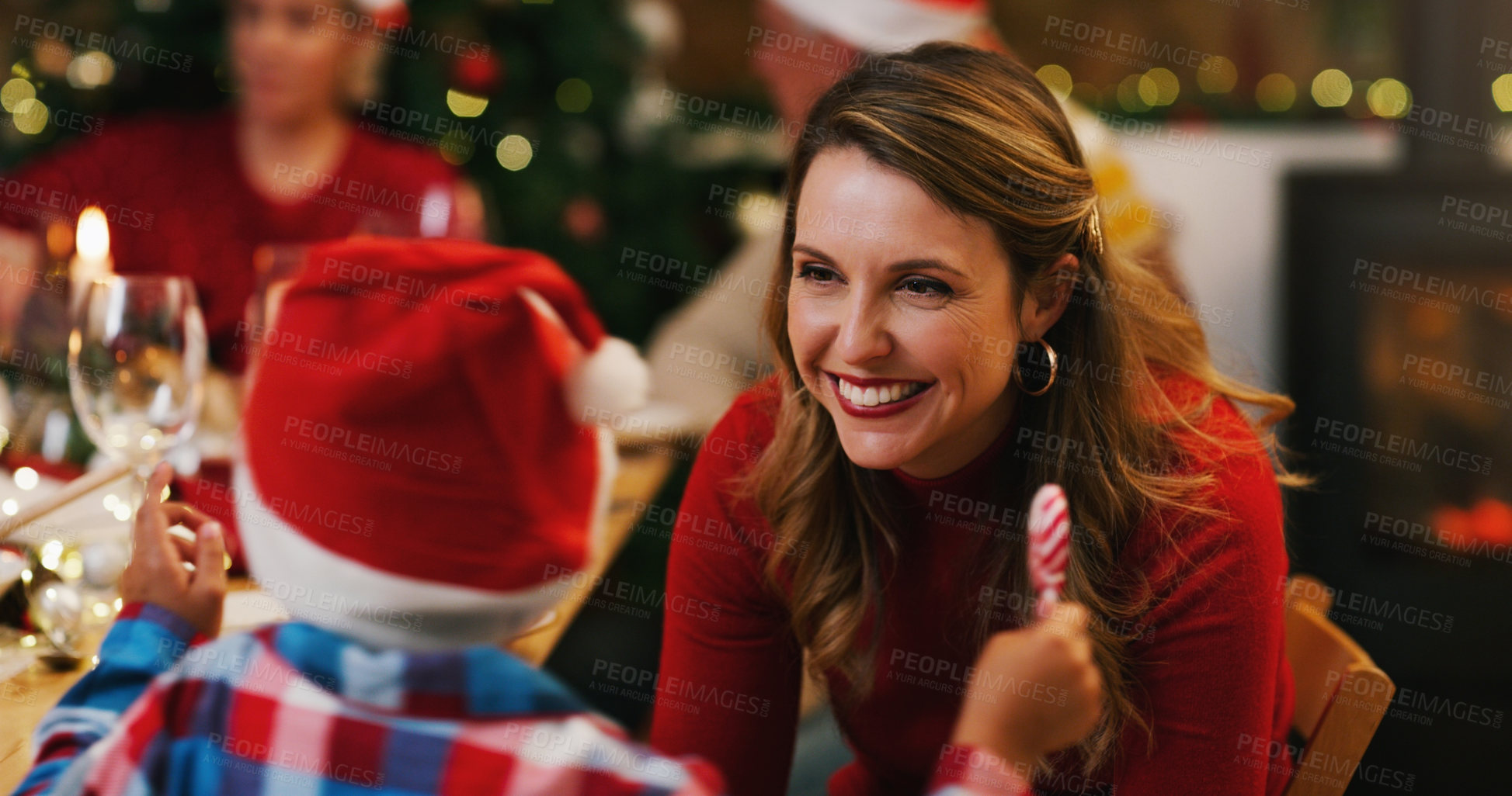 Buy stock photo Shot of a young woman enjoying a Christmas dinner party with her son and family at home