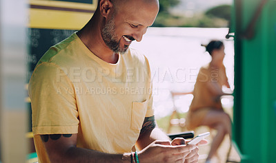 Buy stock photo Shot of a man holding smiling while using his smartphone