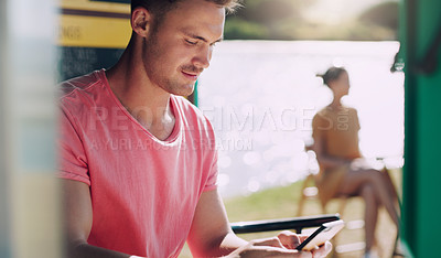 Buy stock photo Shot of a young man using his smartphone