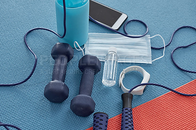 Buy stock photo Studio shot of a variety of workout equipment and PPE on a red and blue yoga mat