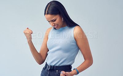 Buy stock photo Cropped shot of an attractive young woman cheering while standing against a grey background in studio