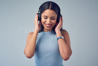 Buy stock photo Headphones, music and woman in studio to relax, chill and enjoy song, playlist and track. Happy, smile and isolated person with audio, radio and podcast for streaming subscription on gray background