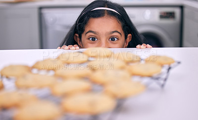 Buy stock photo Shot of a little girl peeking over the kitchen counter at freshly baked cookies