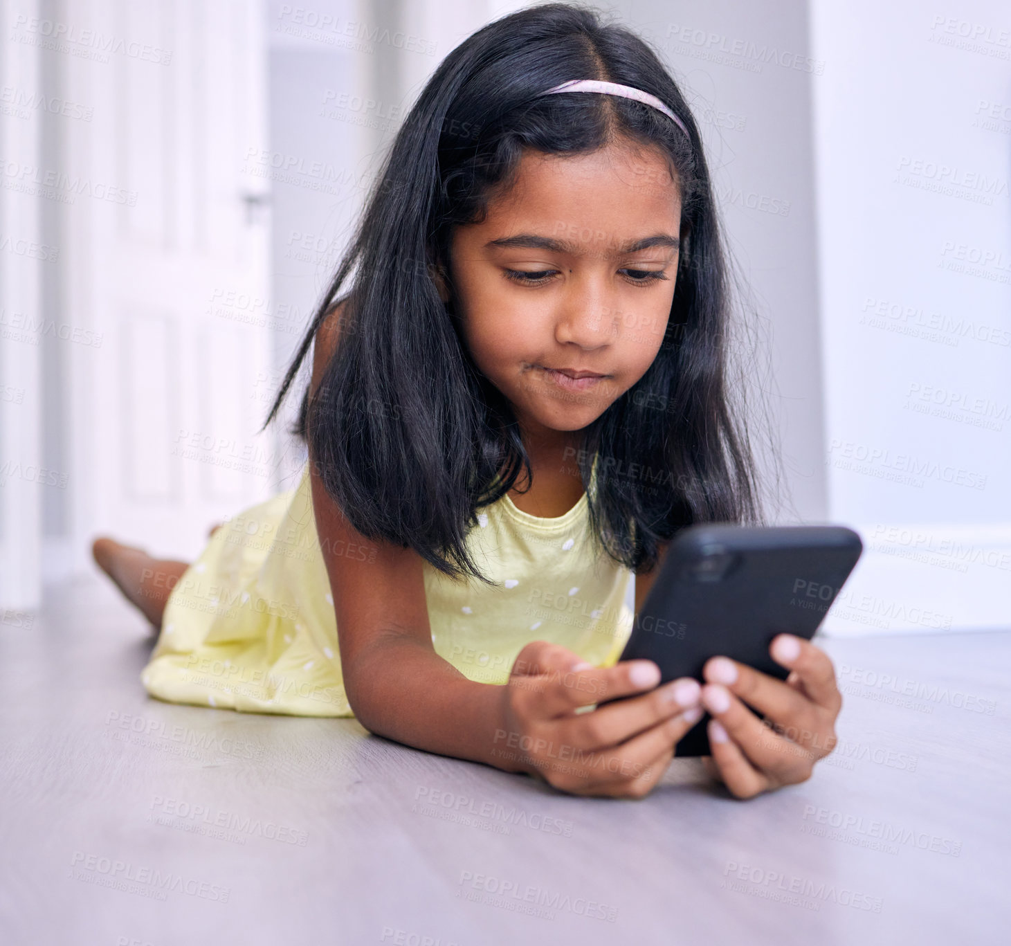 Buy stock photo Phone, relax and child on floor in home watching movie, film or show online for entertainment. Technology, rest and girl kid streaming video on social media, app or internet with cellphone at house.