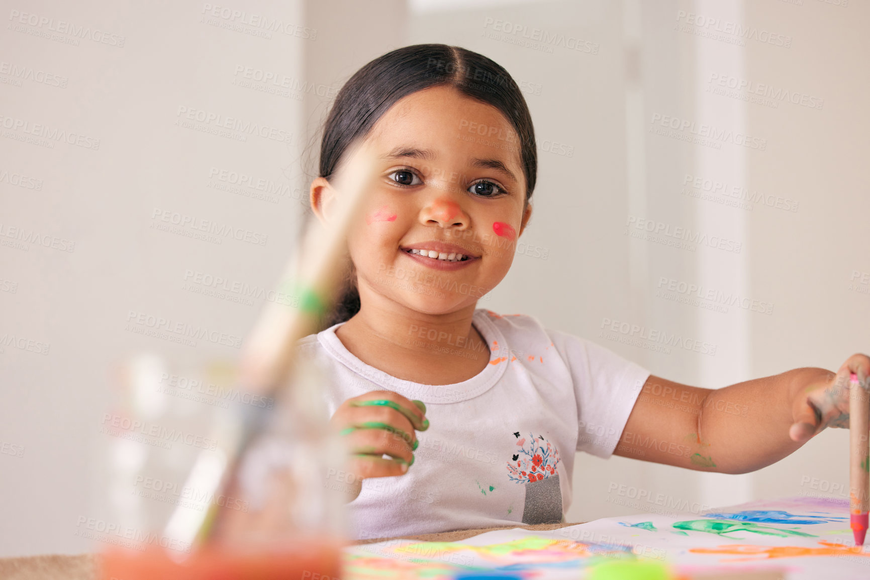 Buy stock photo Shot of an adorable little girl painting while sitting at a table