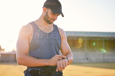 Buy stock photo Cropped shot of a man looking at his watch while working out