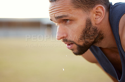 Buy stock photo Cropped shot of a young man looking exhausted while out for a run