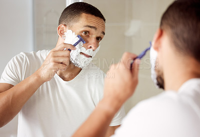 Buy stock photo Man, mirror and shaving beard in bathroom for hygiene or grooming with self care, wellbeing and reflection. Home, confident and cream for hair removal with skincare, routine and positive results