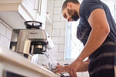 Buy stock photo Mexican man, coffee and machine at home in kitchen to steam or warm milk to relax, chill and rest. House, cappuccino and low angle on countertop, hot and fresh to clean, hygiene and apron as routine