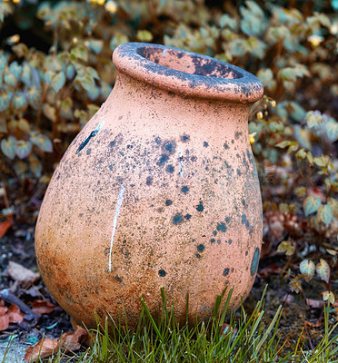 Buy stock photo Old abandoned floral arrangement holder in a backyard ready to be refurbished. Empty ceramic pot in a home garden. Dirty and weathered plant container between grass and plants in a yard during autumn