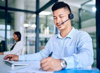 Buy stock photo Man, writing notes and callcenter with telecom, communication and contact us with CRM. Happy working at telemarketing agency, sales and headset with mic for phone call, customer service and support