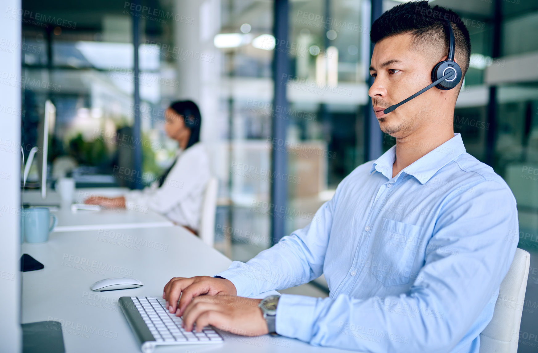 Buy stock photo Call center, man and headset with computer, serious and typing for telemarketing, sales and customer service. Company, agent and corporate with internet, consulting and technology for communication