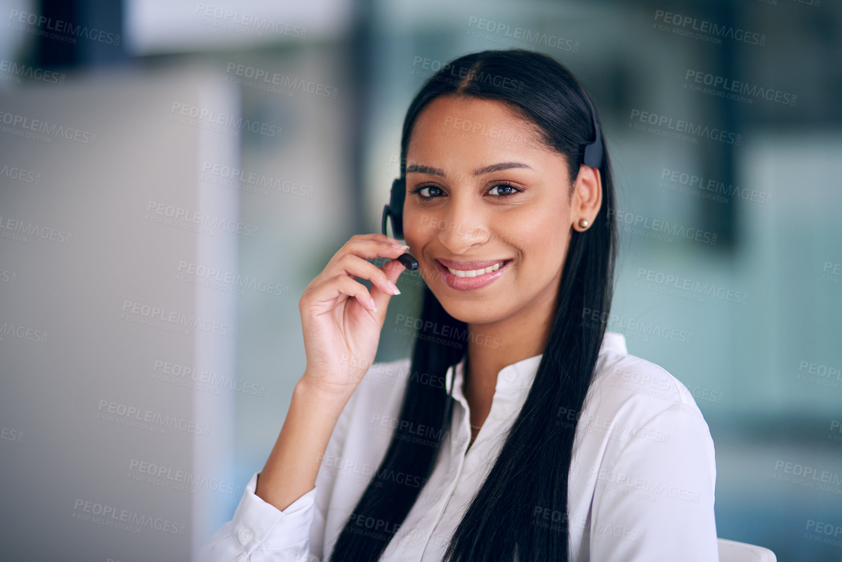 Buy stock photo Shot of a young woman using a headset and computer in a modern office