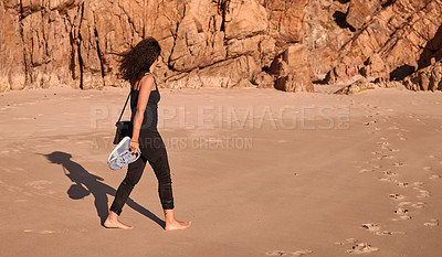 Buy stock photo Woman, walking and beach with shoes in nature for fresh air, freedom or outdoor weekend by sand and rocks. Rear view of female person on holiday, vacation or barefoot stroll for travel by ocean coast