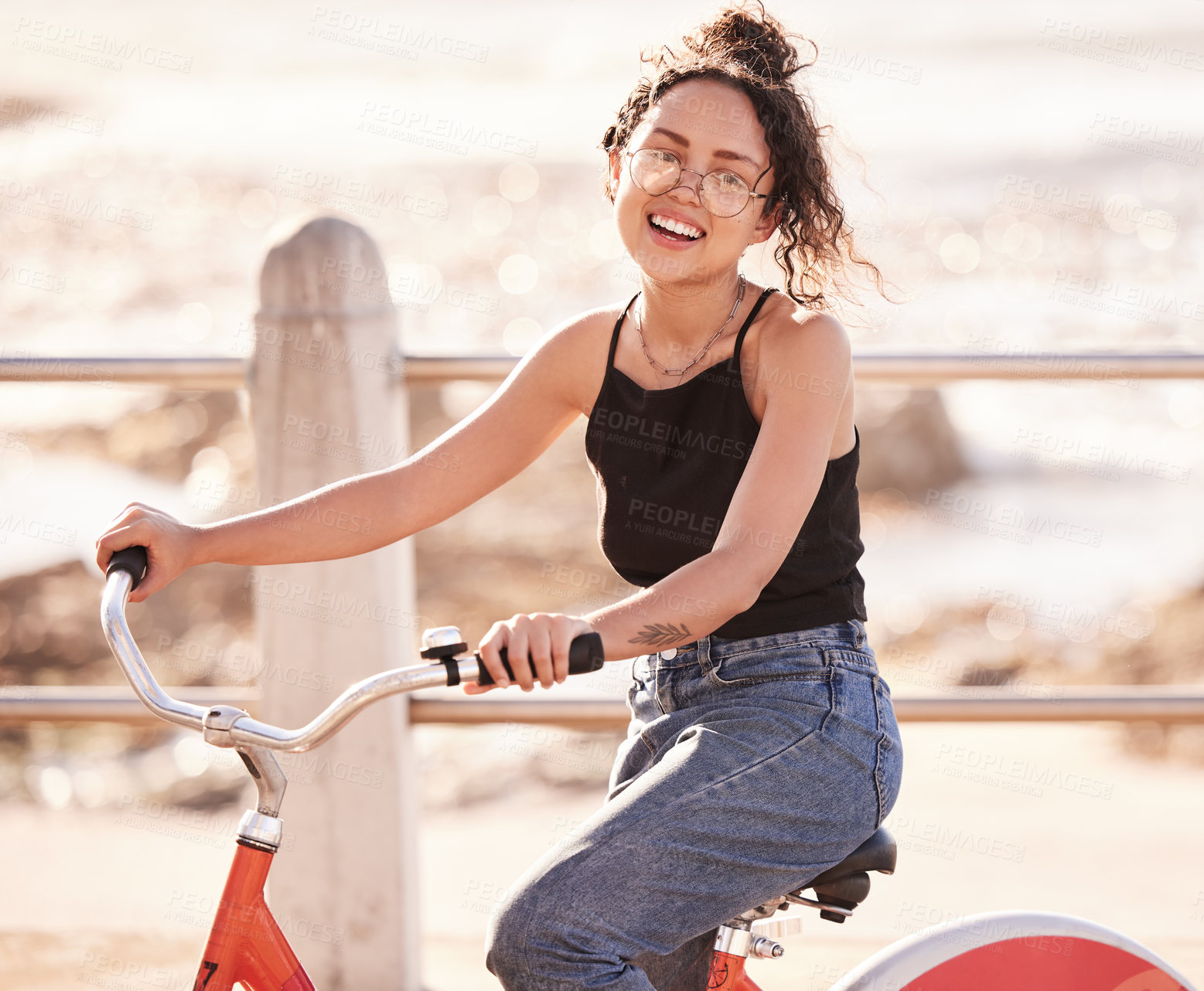 Buy stock photo Shot of a young woman riding a bicycle on the promenade