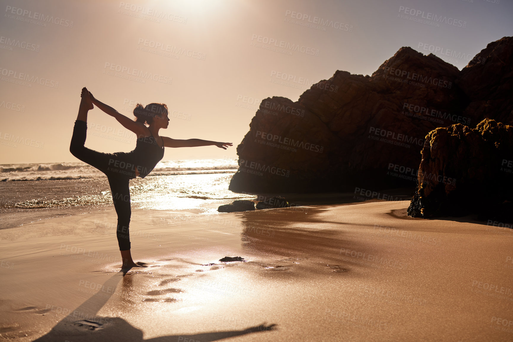 Buy stock photo Shot of a young woman practicing yoga at the beach