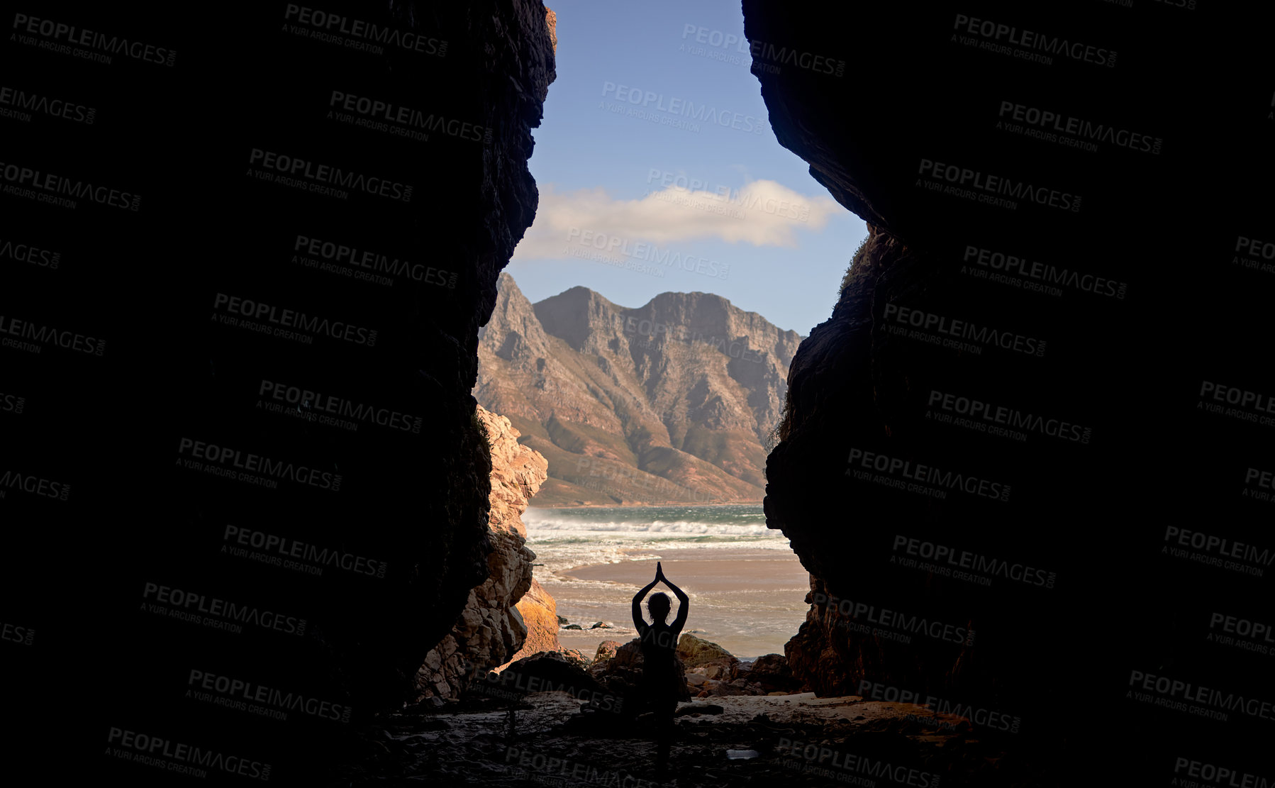 Buy stock photo Shot of a woman practising yoga while sitting in a cave overlooking the sea