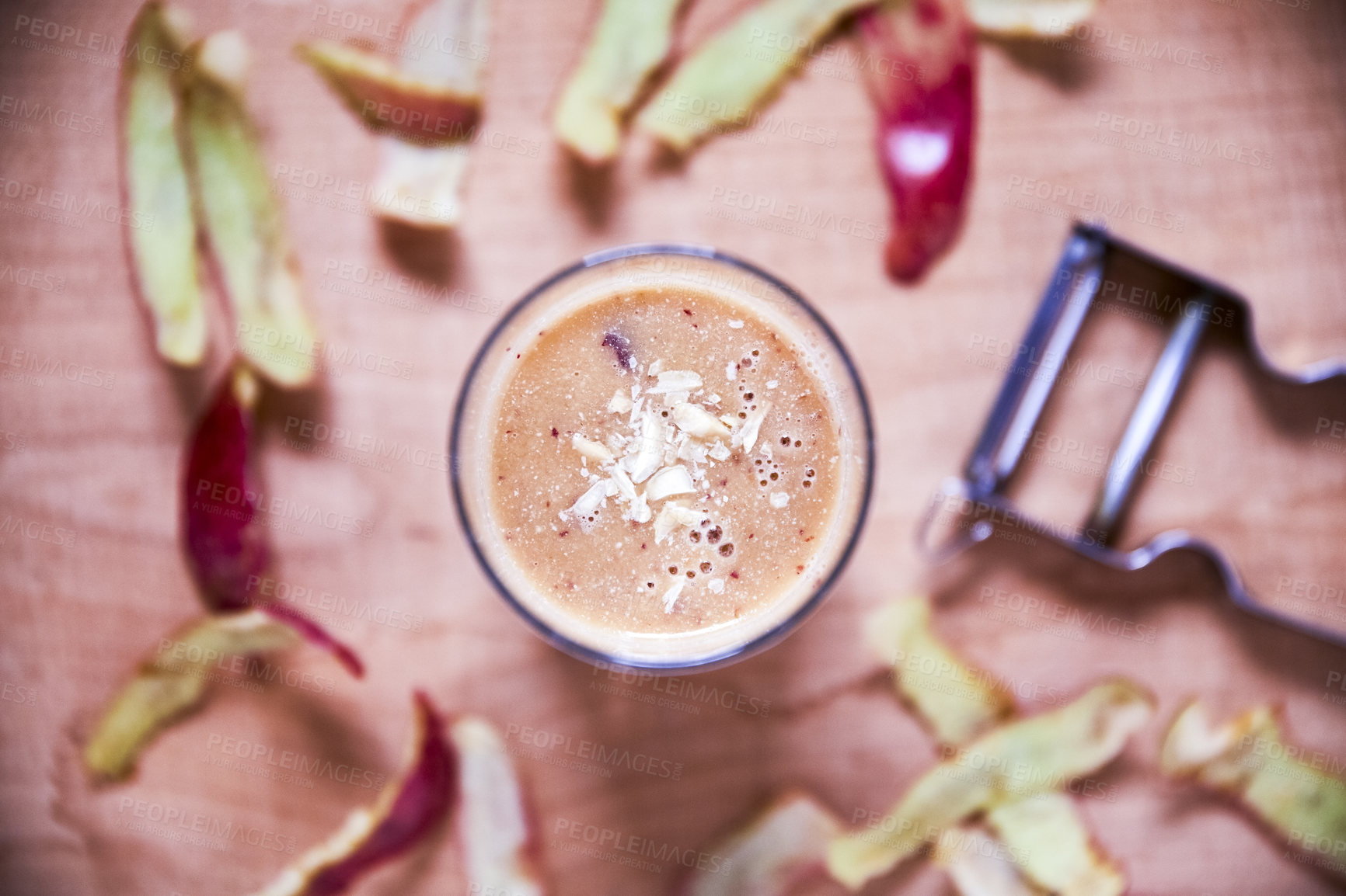 Buy stock photo Overhead shot of an apple smoothie topped with sliced almonds on a wooden board