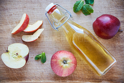 Buy stock photo Overhead shot of a bottle of apple cider vinegar on a wooden table