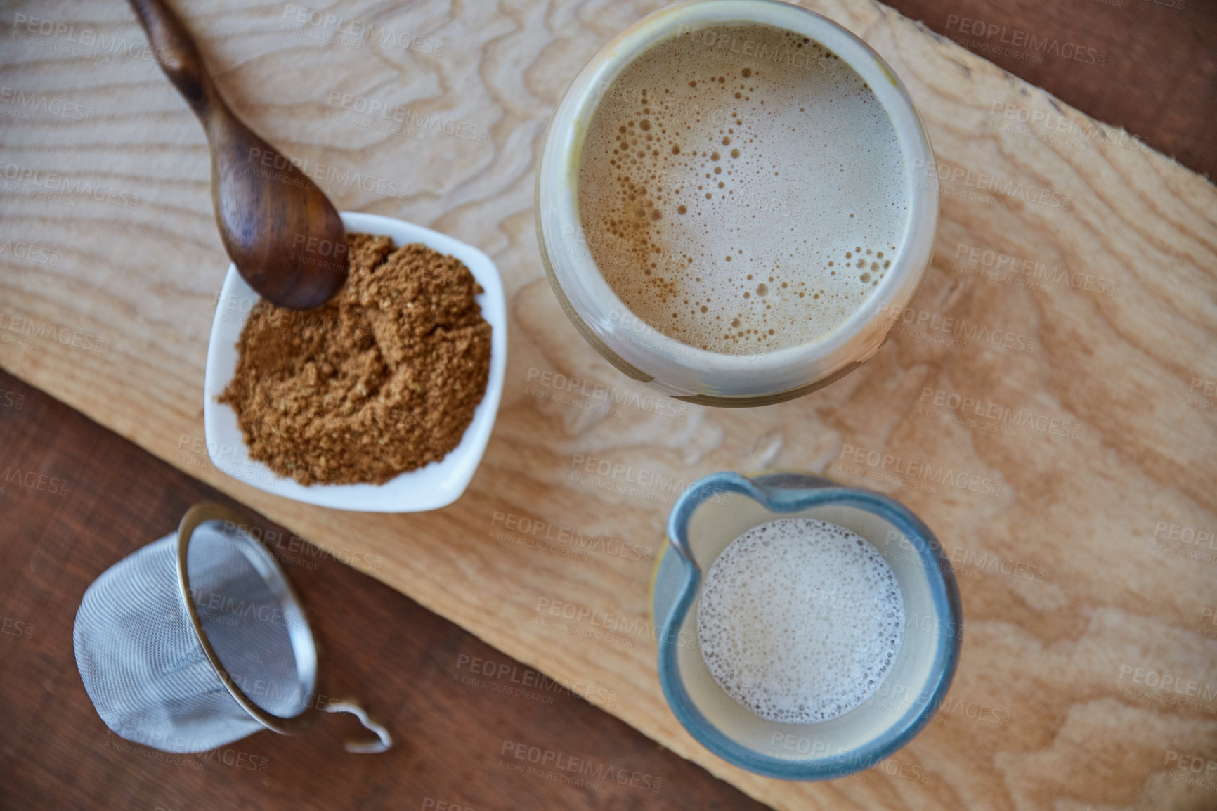 Buy stock photo Overhead shot of jugs of plant based milk and a ramekin of ground nuts on a wooden board