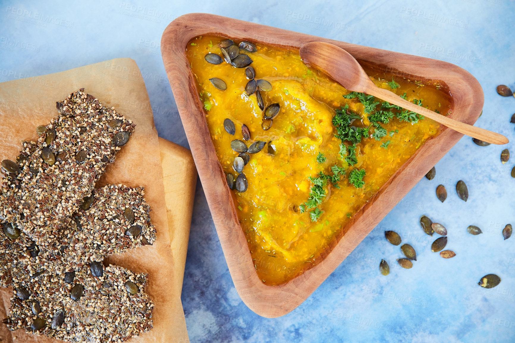 Buy stock photo Overhead shot of seed crackers and a pumpkin puree on a blue background