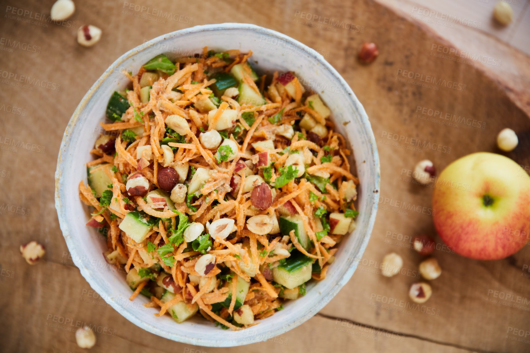 Buy stock photo Overhead shot of a health salad in a white serving bowl on a wooden table