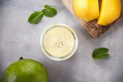 Buy stock photo Overhead shot of a mango smoothie on a grey background