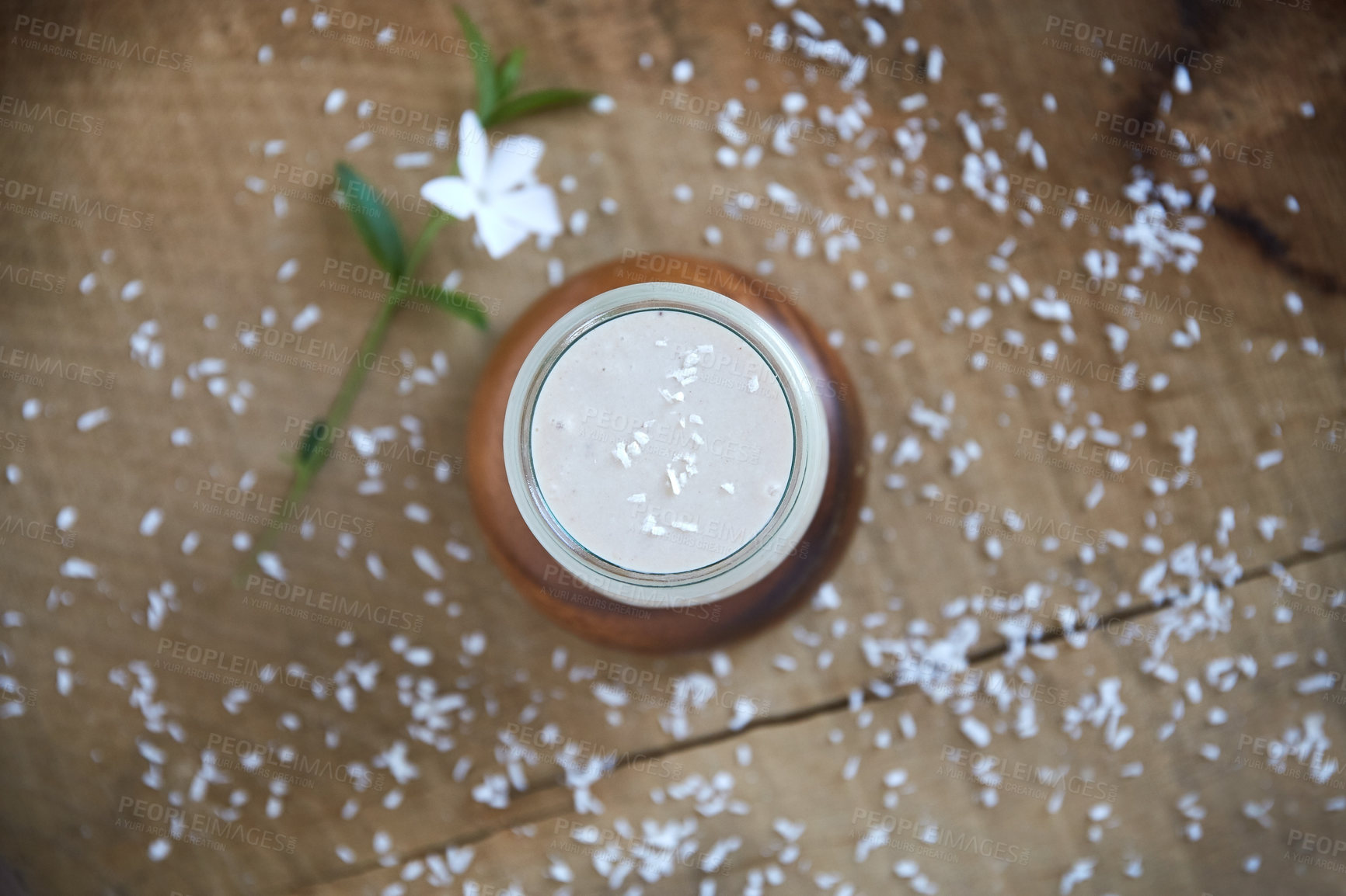 Buy stock photo Overhead shot of a coconut smoothie on a wooden table