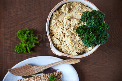 Buy stock photo Overhead shot of a cauliflower pâté in a ceramic serving dish accompanied with seed crackers on a wooden table