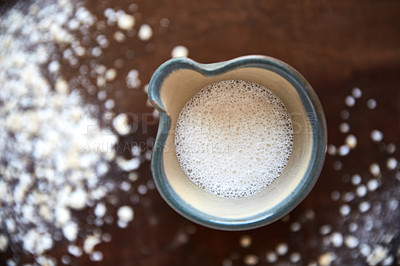 Buy stock photo Overhead shot of a jug of plant based milk on a wooden table