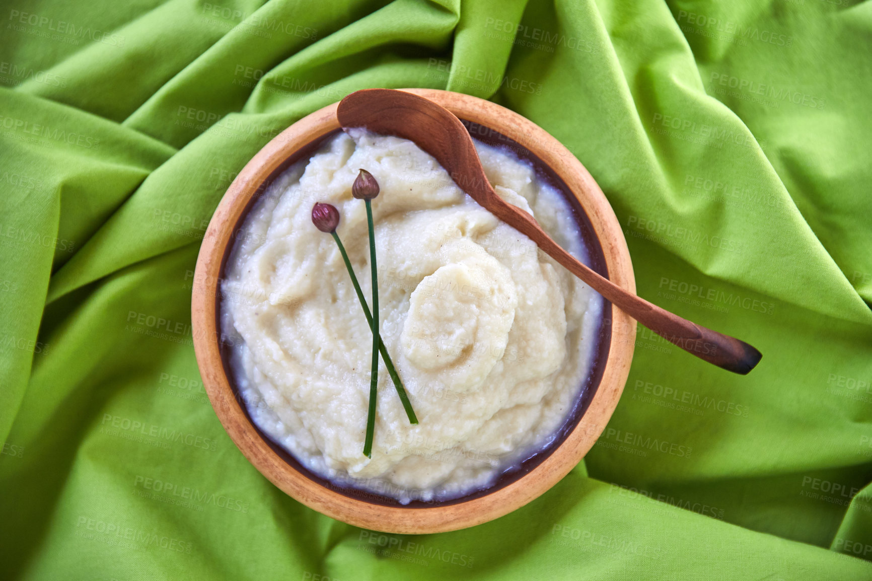 Buy stock photo Overhead shot of cauliflower mash puree in a wooden bowl on a green tablecloth