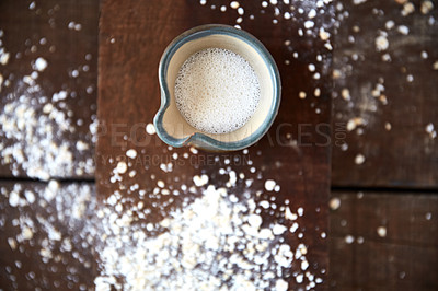 Buy stock photo Overhead shot of a jug of plant based milk on a wooden table