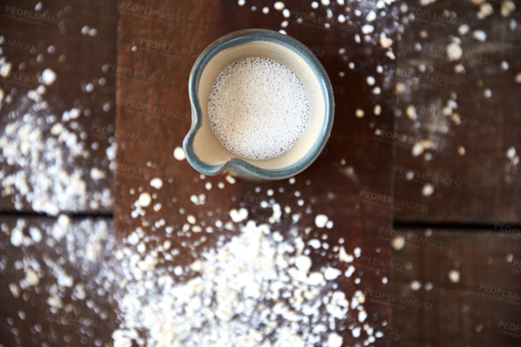 Buy stock photo Overhead shot of a jug of plant based milk on a wooden table