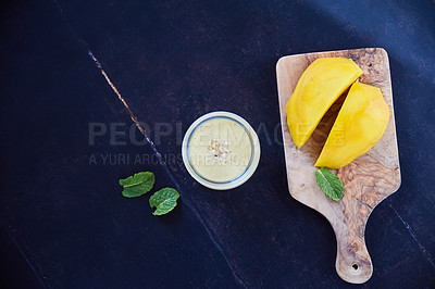 Buy stock photo Overhead shot of a mango and mint smoothie on a black background