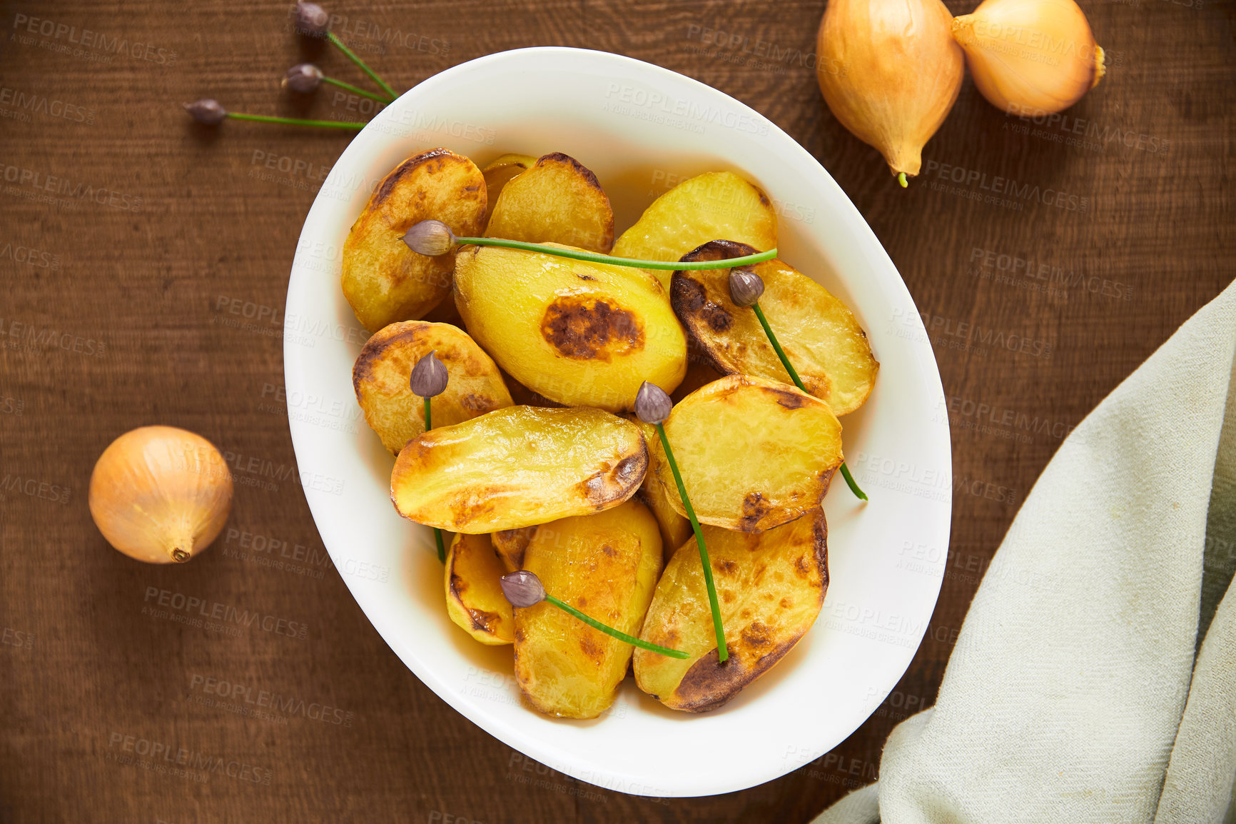 Buy stock photo Overhead shot of roasted potatoes in a white serving bowl