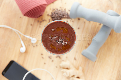 Buy stock photo Overhead shot of a cocoa smoothie surrounded by fitness equipment on a wooden table