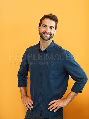 Buy stock photo Cropped portrait of a handsome young businessman standing alone against a yellow background in the studio
