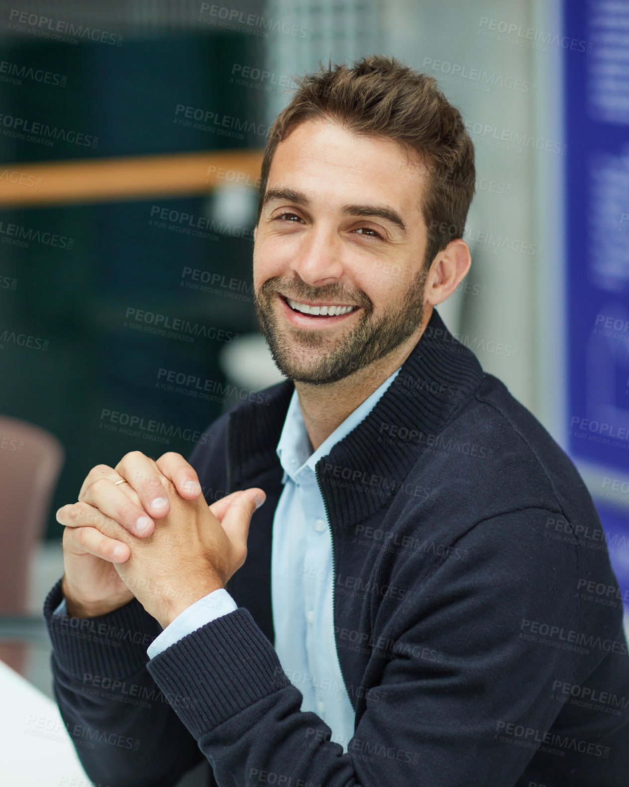 Buy stock photo Cropped portrait of a handsome young businessman sitting alone in an office space during the day