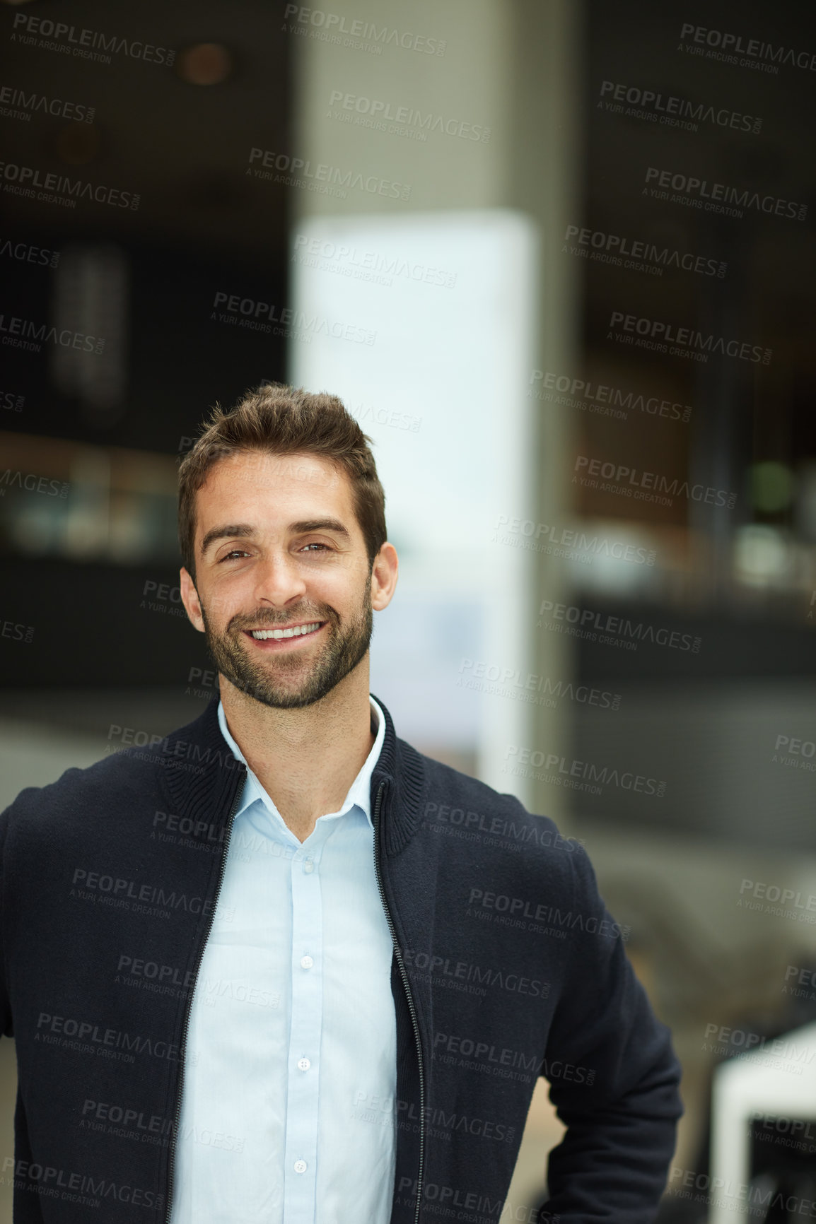 Buy stock photo Cropped portrait of a handsome young businessman standing alone in an office space during the day