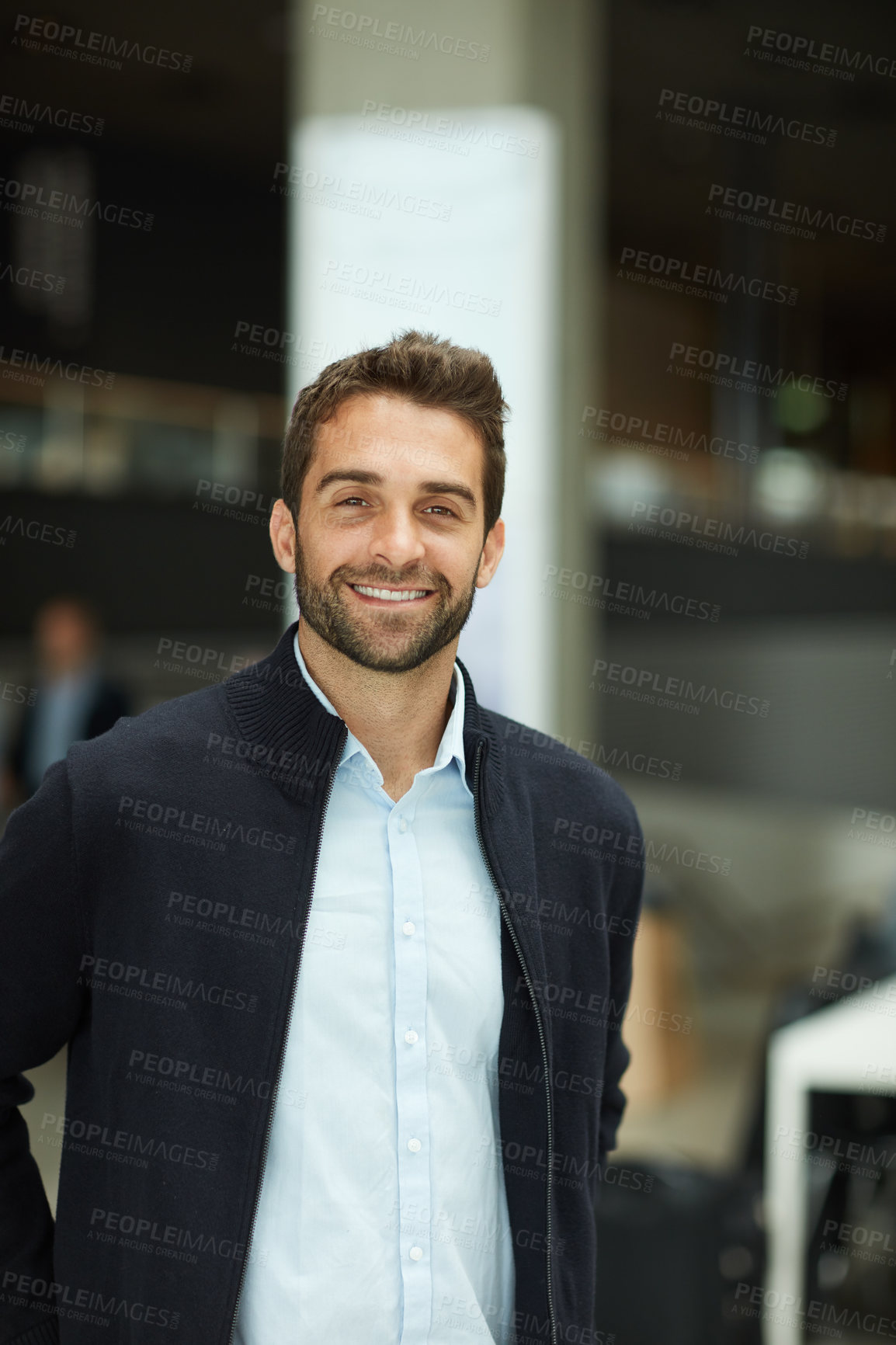 Buy stock photo Cropped portrait of a handsome young businessman standing alone in an office space during the day