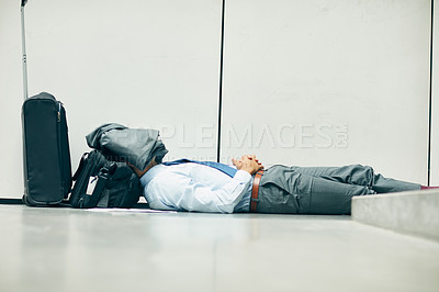Buy stock photo Cropped shot of an unrecognizable businessman sleeping in an airport terminal and covering his face with his jacket