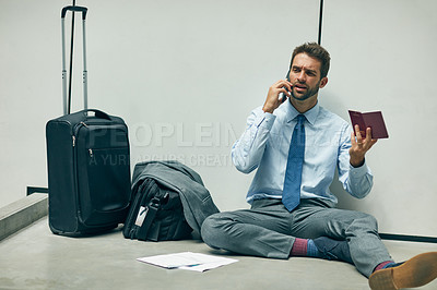 Buy stock photo Cropped shot of a handsome young businessman sitting in an airport terminal and using his cellphone while holding his passport