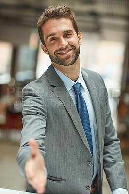 Buy stock photo Cropped portrait of a handsome young businessman standing alone and extending his hand for a handshake