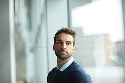Buy stock photo Cropped shot of a handsome young businessman standing alone and looking contemplative