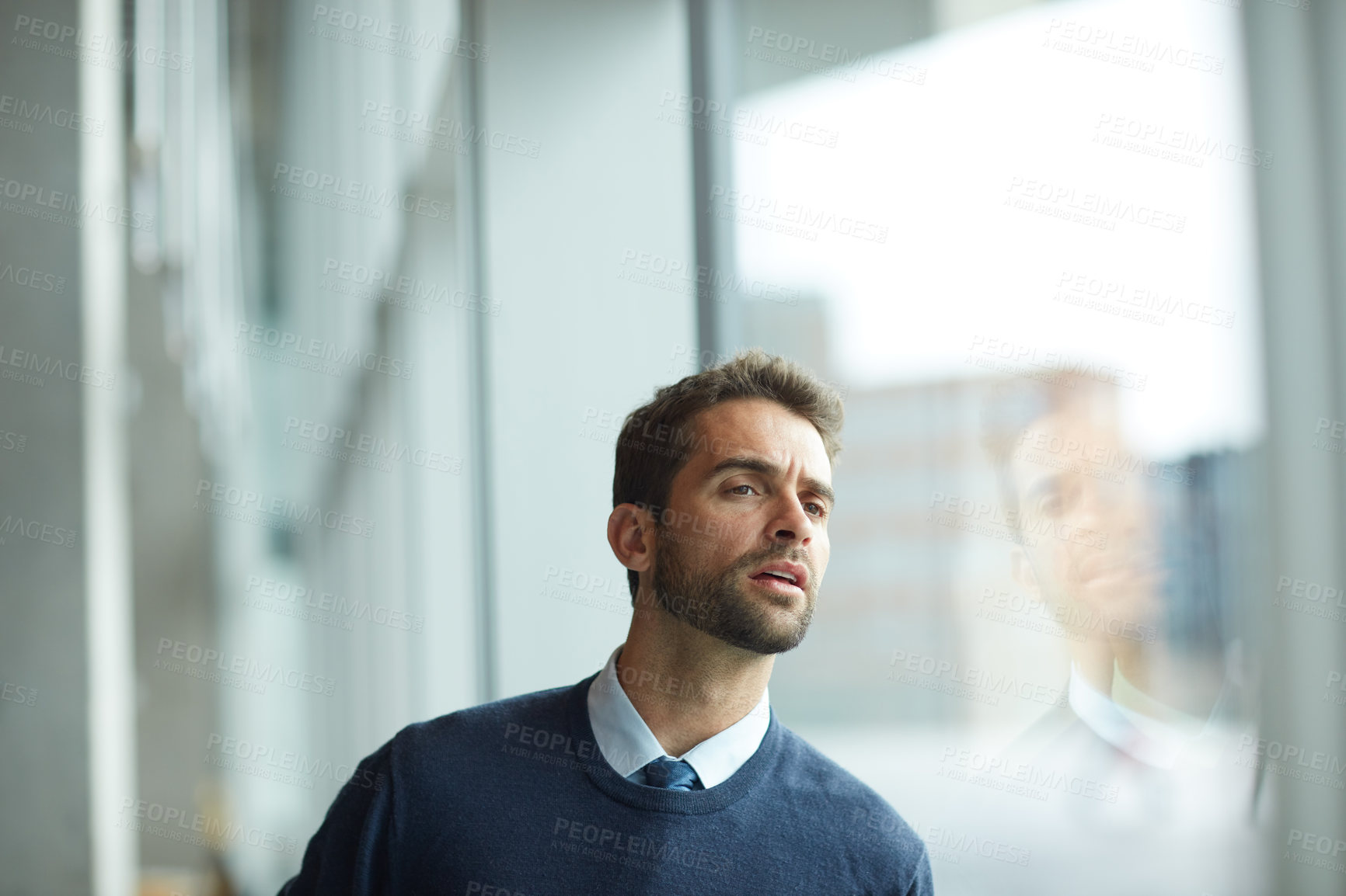 Buy stock photo Cropped shot of a handsome young businessman standing alone and looking confused