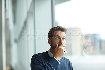 Buy stock photo Cropped shot of a handsome young businessman standing alone and looking shocked