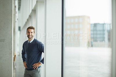 Buy stock photo Cropped portrait of a handsome young businessman standing alone indoors with his hands on his hips during the day